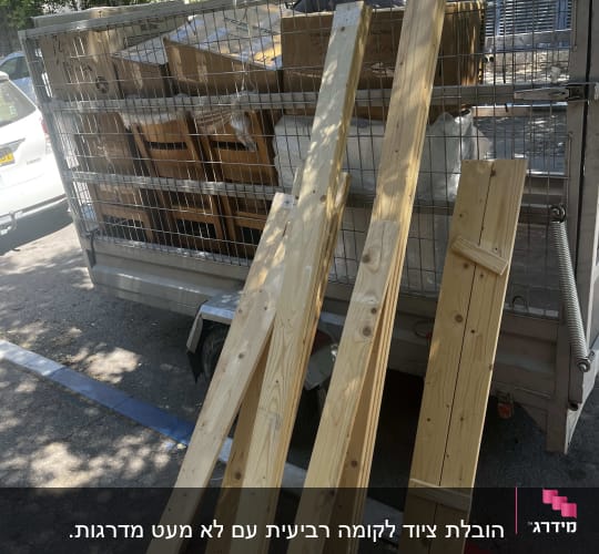 נגררת הובלות עמוסה בארגזים, כיסאות ולוחות עץ מפורקים